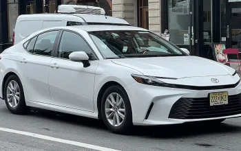 Tampilan depan dan samping Toyota Camry generasi terbaru dengan desain modern rendah dan elegan